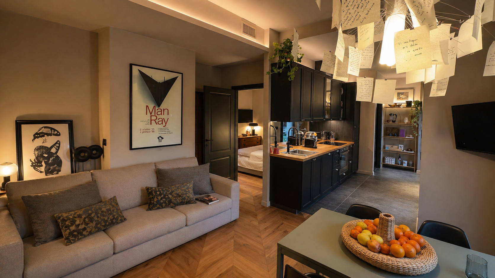 Villa Irene Langhe open-plan living and black kitchen with manuscript-paper chandelier
