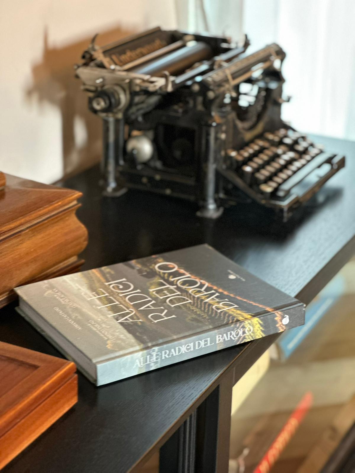 Vintage Underwood typewriter beside 'Alle radici del Barolo' book — Villa Irene Langhe detail